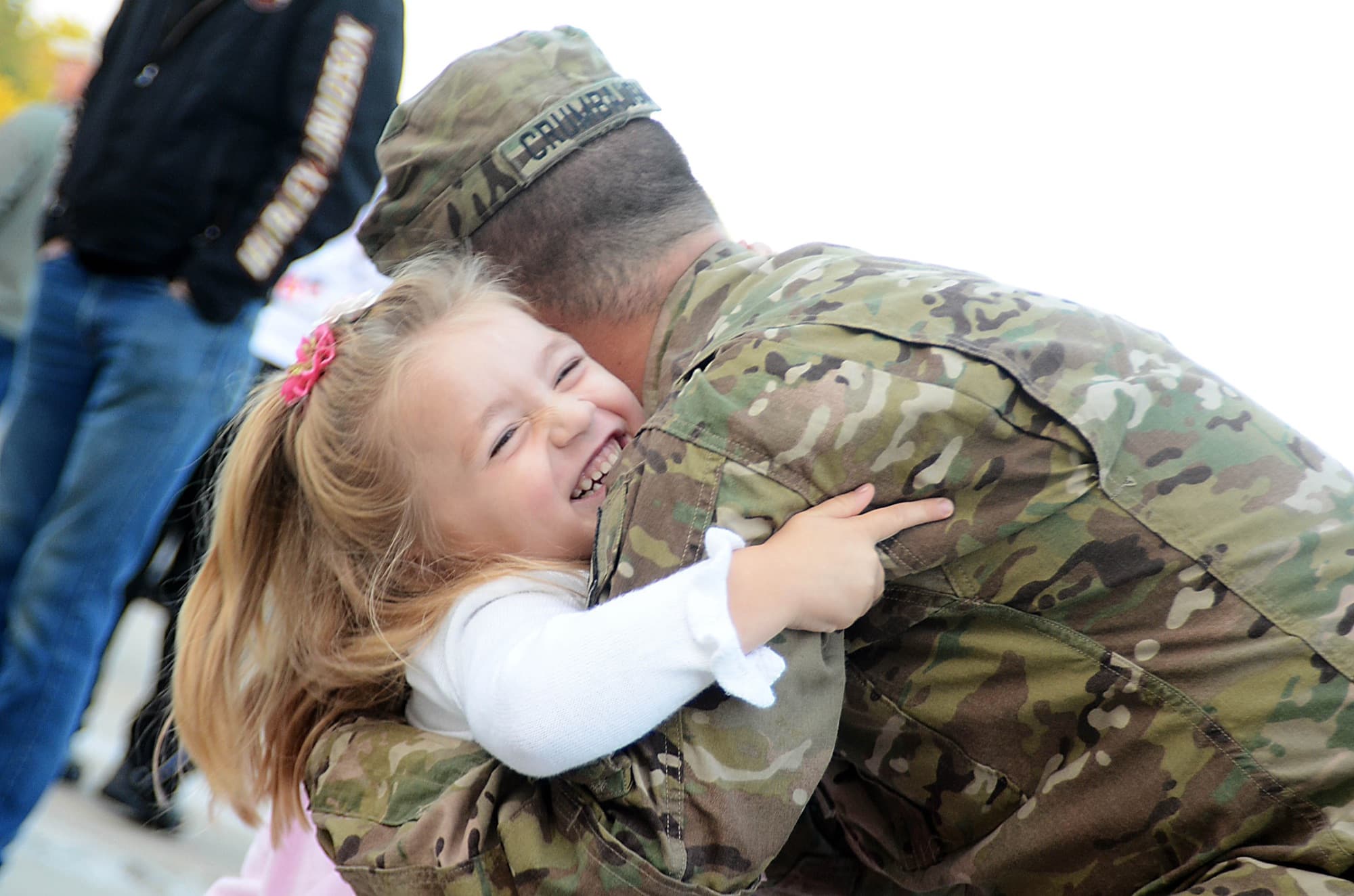 A National Guard soldier is welcomed home by his young daughter in civilian clothes