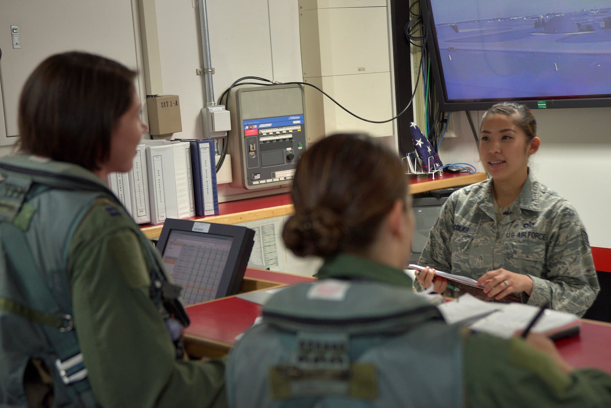 Two female F-16 pilots in flight gear briefing at Misawa Air Base, Japan