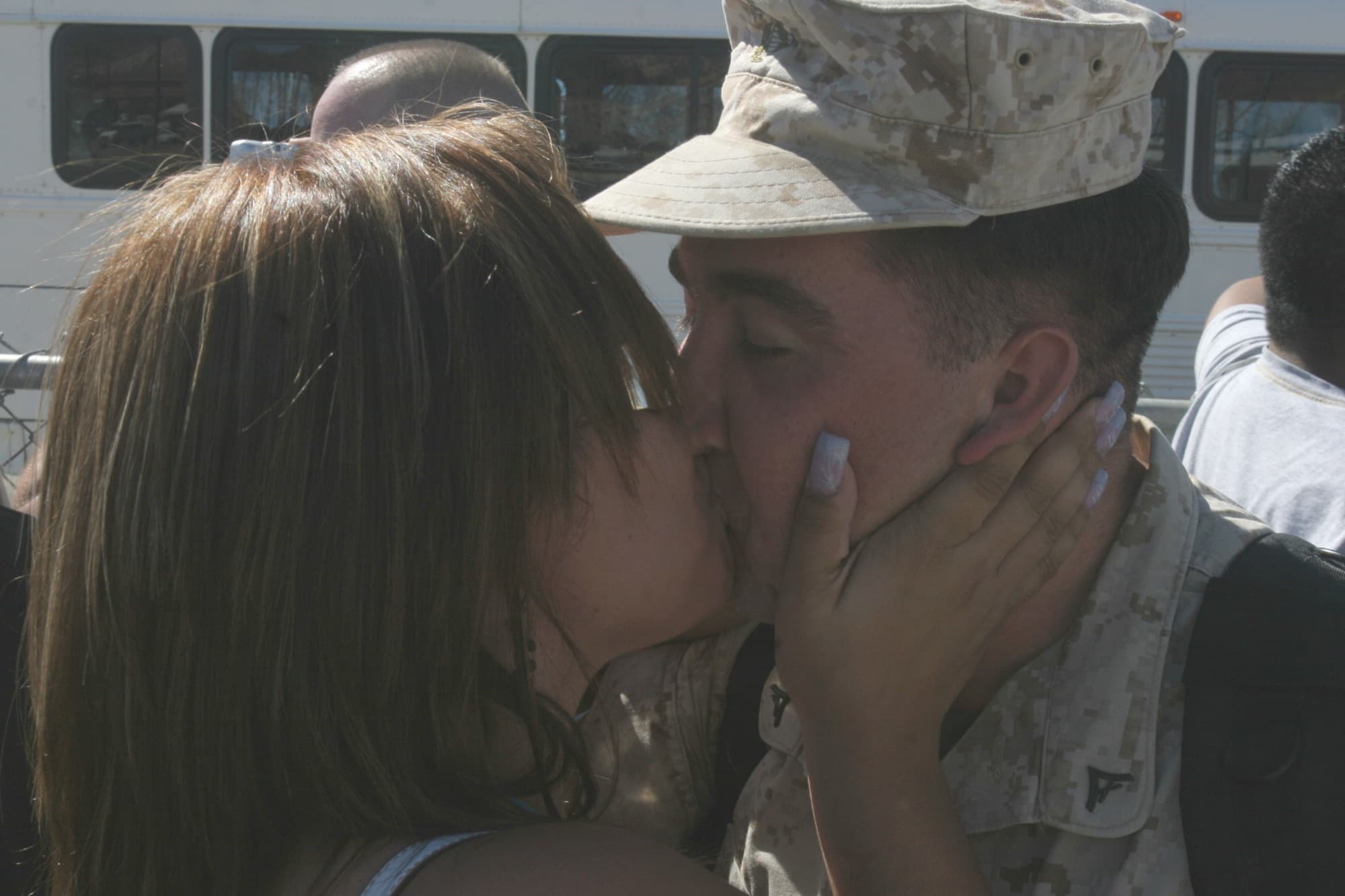 A Marine in uniform reunites with his wife at a homecoming