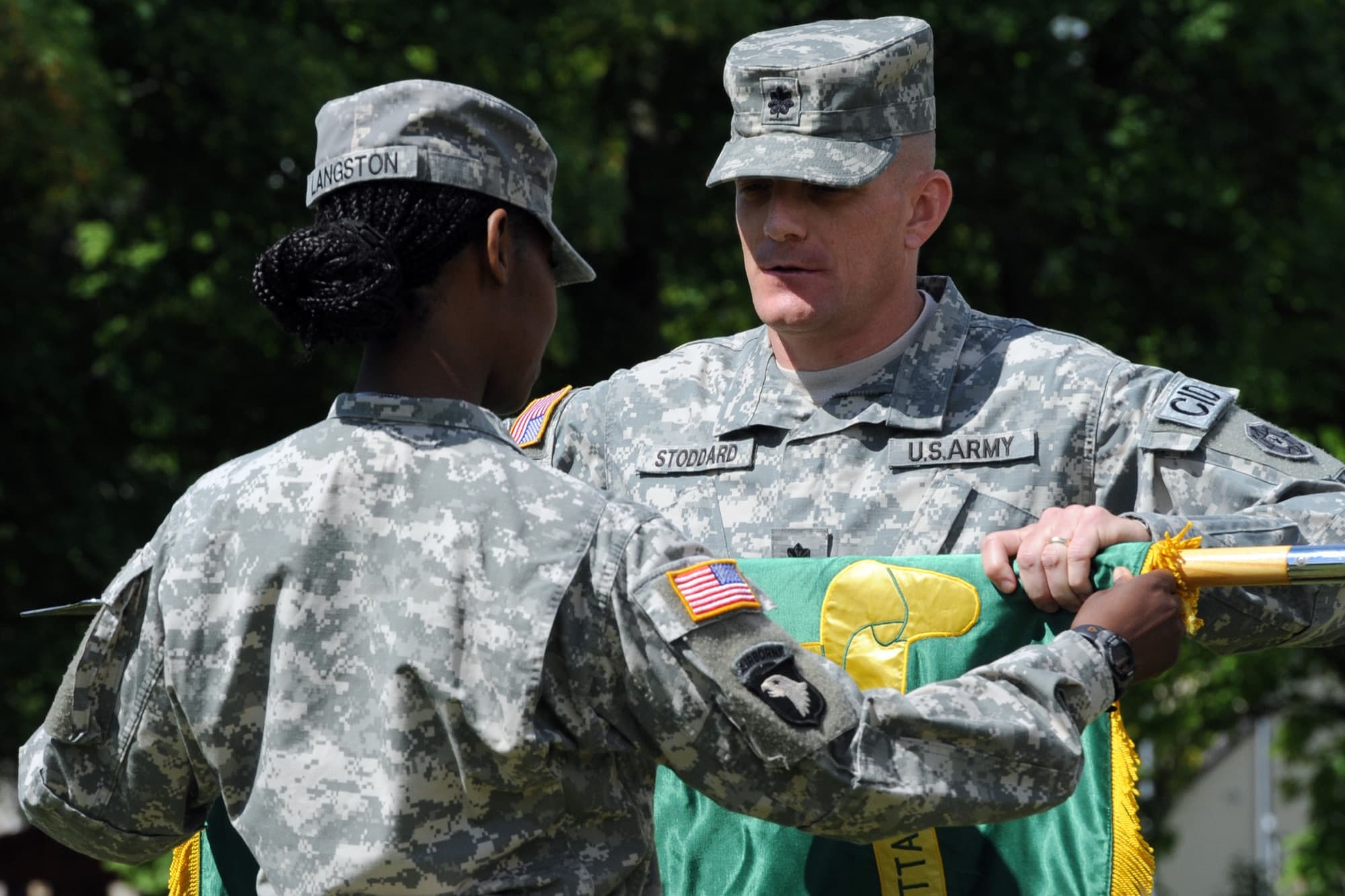 A Black woman Army first sergeant and a White male lieutenant colonel casing battalion colors
